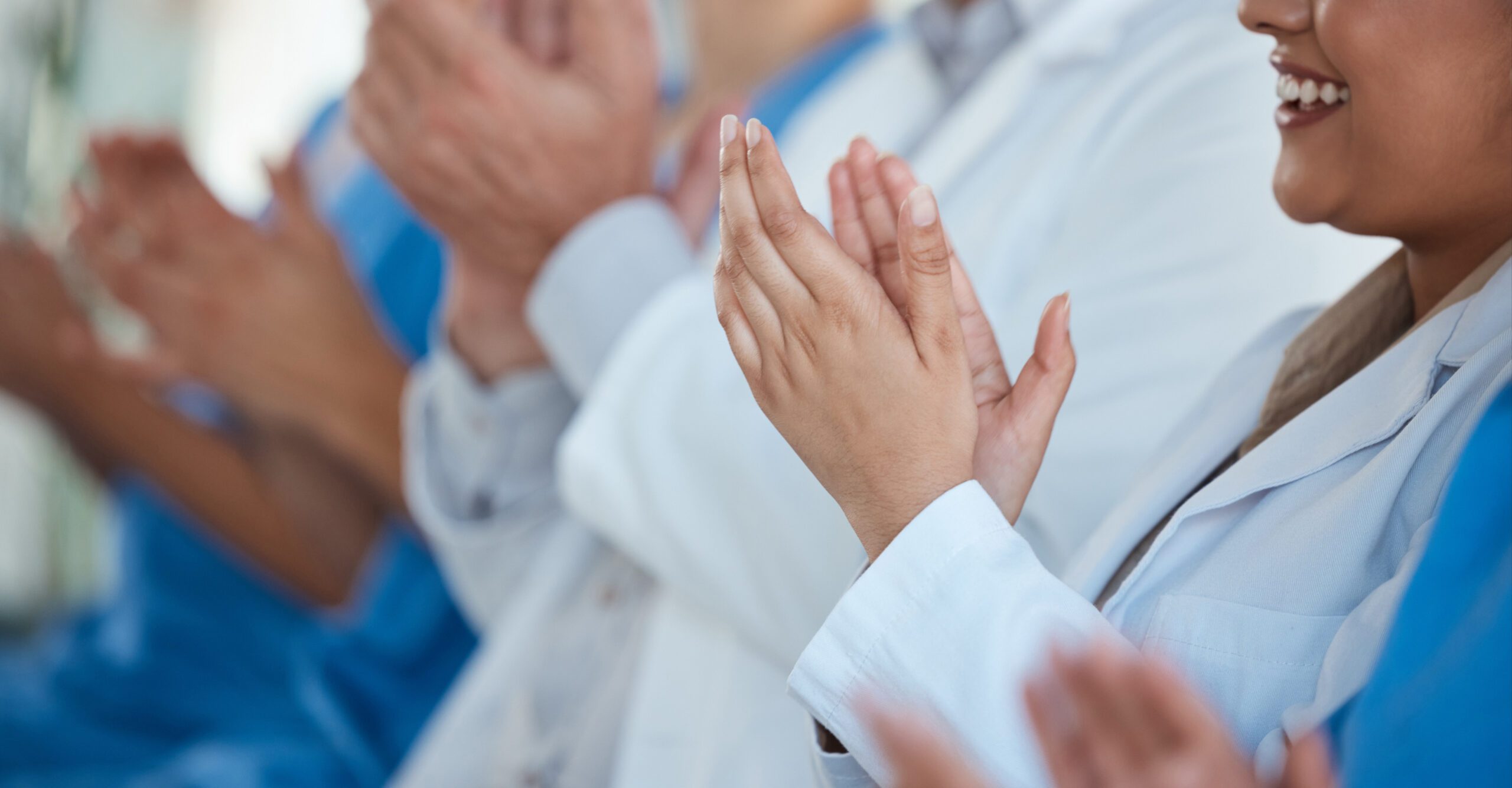 Conference, medial team and smile with applause on presentation for well done and good job. People, row and happy as healthcare profession with clapping hands at seminar for success and achievement.